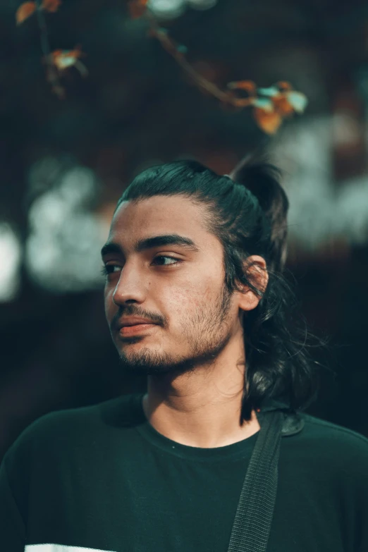 a man with long hair wearing a black shirt, trending on unsplash, hurufiyya, south east asian with round face, non binary model, ponytail, raden saleh
