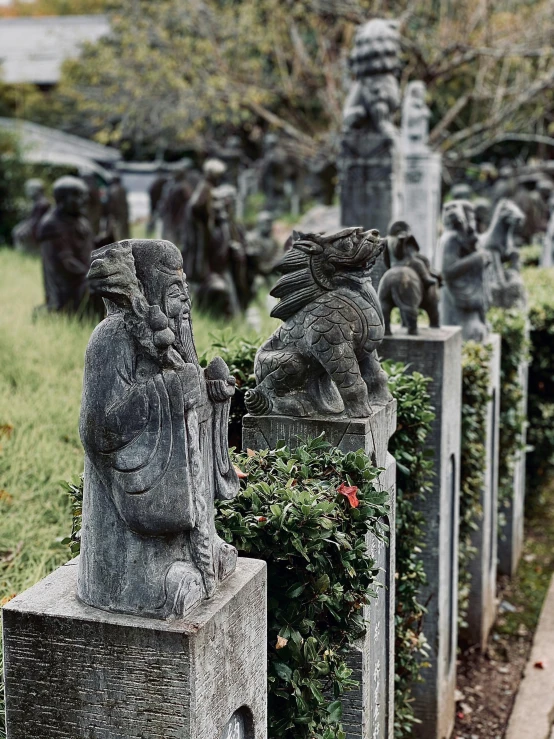 a group of statues sitting on top of cement blocks, in a graveyard, lulu chen, high-quality photo, japanese village