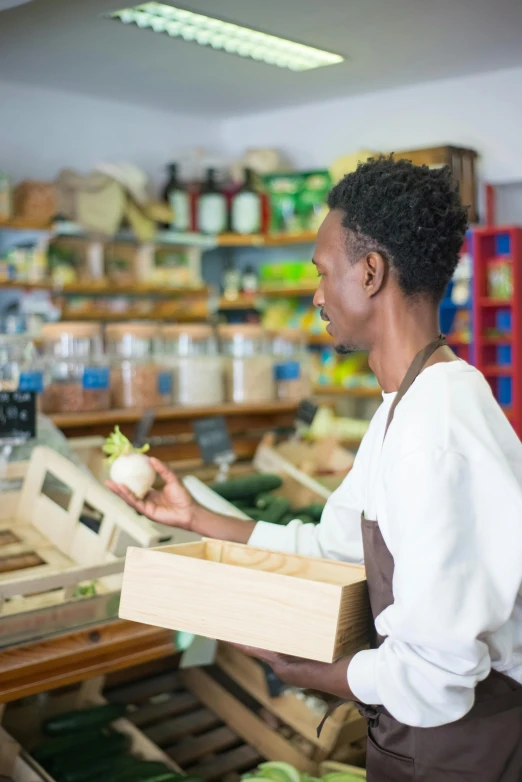 a woman holding a box in a grocery store, trending on unsplash, happening, black man with afro hair, square, ethiopian, carefully crafted