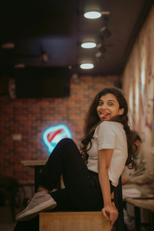 a woman sitting on top of a wooden box, by Max Dauthendey, pexels contest winner, sitting at the bar, mutahar laughing, indian, trending on artstion