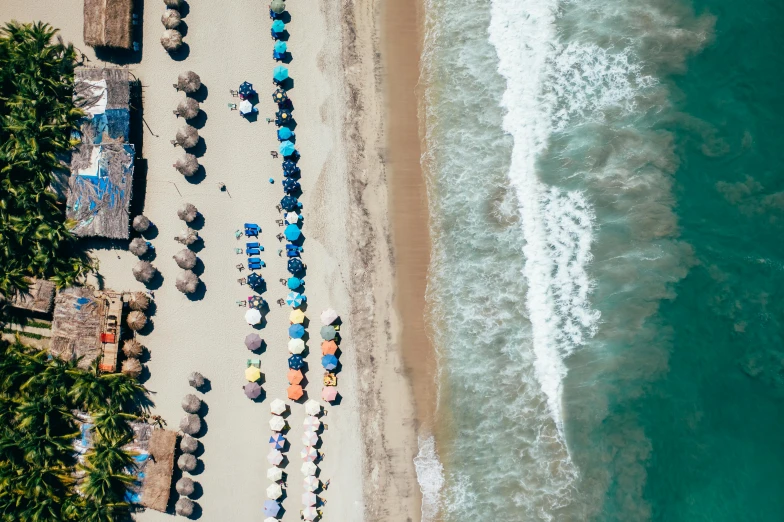 a beach filled with lots of umbrellas next to the ocean, unsplash contest winner, marbella, aerial, profile image, greece