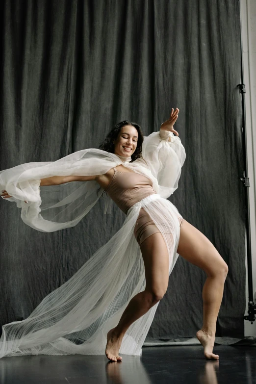 a woman in a white dress posing for a picture, arabesque, wearing translucent sheet, kailee mandel, interacting and posing, in a photo studio