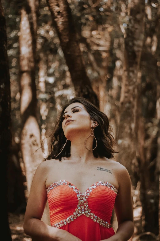 a woman in a red dress standing in the woods, an album cover, by Briana Mora, pexels contest winner, sunny leone, gazing off into the horizon, profile image, sleeveless