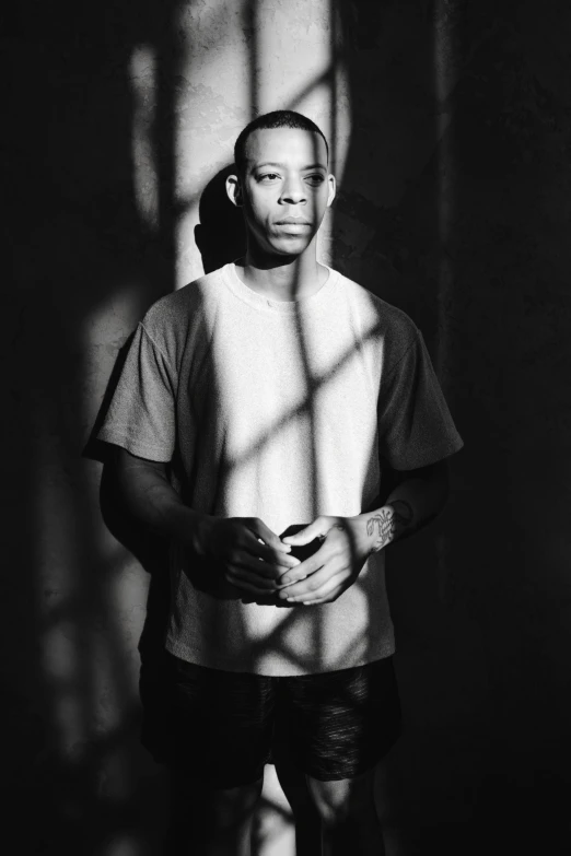 a black and white photo of a man standing in front of a window, by Vincent Evans, renaissance, dr dre, black main color, gustavo fring, freeway