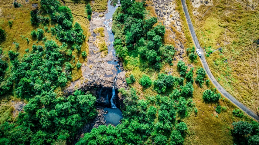 a river running through a lush green forest, by Daniel Lieske, pexels contest winner, hurufiyya, aerial view of an ancient land, next to a waterfall, landscape of africa, thumbnail