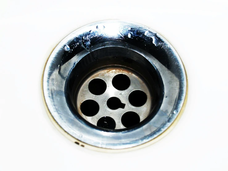 a metal sink drain with holes in it, pexels, hurufiyya, dividing it into nine quarters, acid leaking from mouth, 2000s photo, plain background