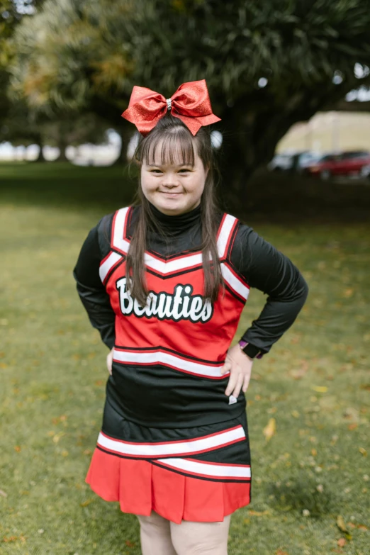 a girl in a cheer uniform posing for a picture, profile image, no legs, a red bow in her hair, beans