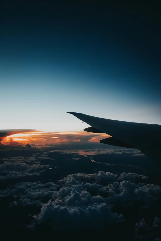 an airplane wing flying above the clouds at sunset, by Sebastian Spreng, pexels contest winner, gazing off into the horizon, spaceships in the sky, unsplash photography, multiple stories