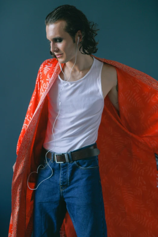 a man in a white shirt and a red cape, inspired by Bert Stern, trending on pexels, skinny caucasian young man, wearing a camisole, ( ( ( wearing jeans ) ) ), non binary model