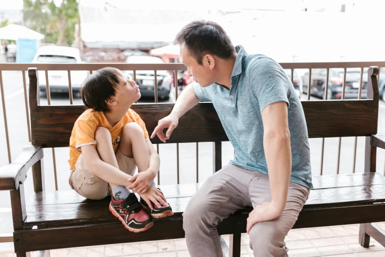 a man and a woman sitting on a bench, pexels contest winner, shin hanga, with a kid, talking, father with child, facing sideways