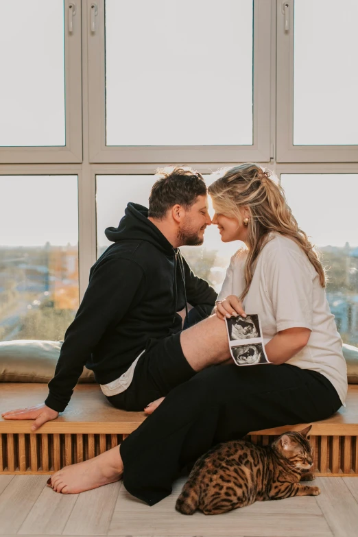 a man and woman sitting on a bench next to a cat, a polaroid photo, happening, pregnancy, big windows, soccer player timo werner, profile image