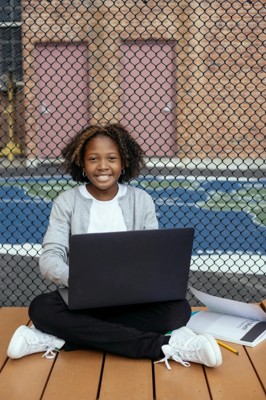 a young girl sitting on the ground with a laptop, by Carey Morris, computer science, jemal shabazz, nets, american school