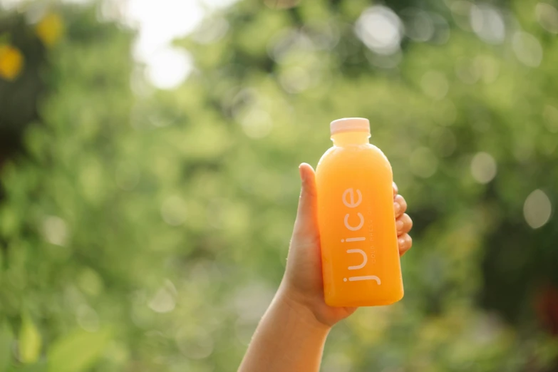 a person holding a bottle of juice in their hand, by Jessie Algie, pexels contest winner, al fresco, gradient orange, close-up product photo, 15081959 21121991 01012000 4k