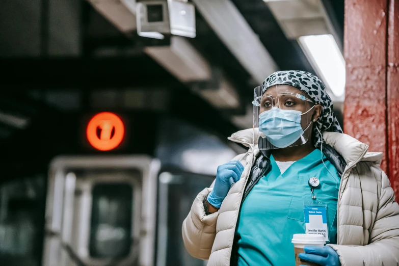 a woman wearing a face mask and gloves, by Meredith Dillman, pexels contest winner, happening, orange line, nurse, nyc, thumbnail