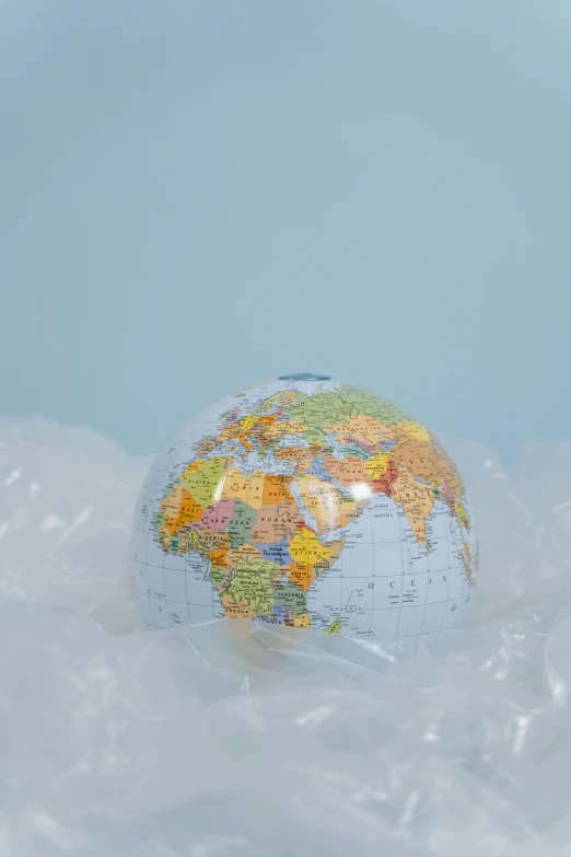 a globe sitting on top of a pile of ice, sitting in a fluffy cloud, dressed in plastic bags, made of silk paper, promo image