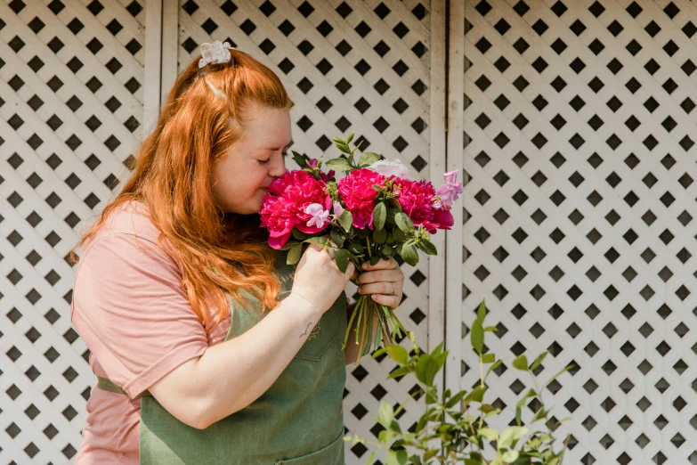 a woman holding a bunch of flowers in her hands, by Meredith Dillman, pexels contest winner, sadie sink, making out, gardening, wearing pink floral chiton