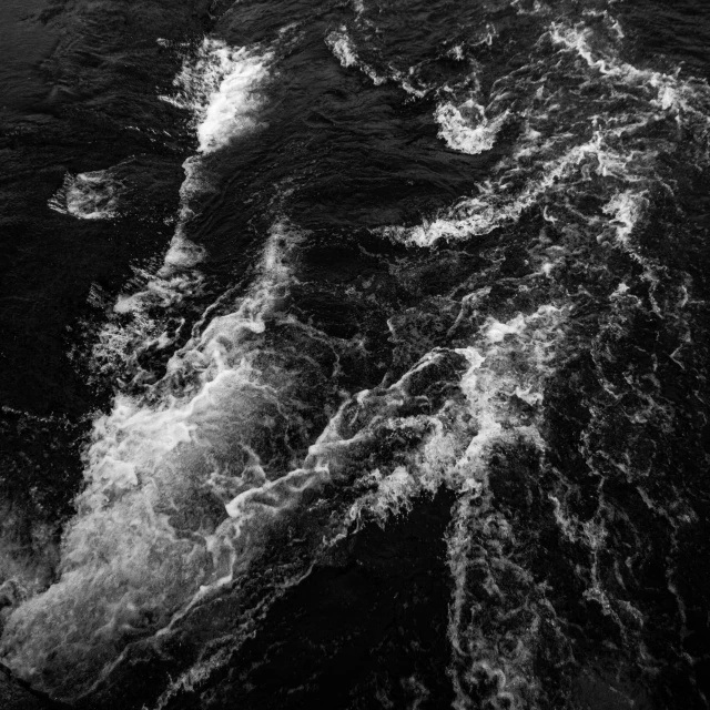 a black and white photo of a body of water, by Jacob Toorenvliet, pexels, process art, water torrent background, a high angle shot, water surrounds the ship, hd footage