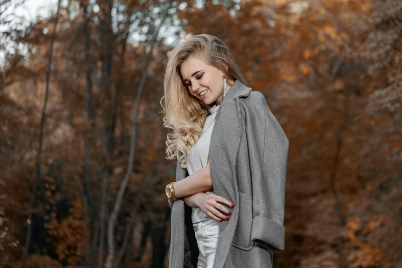 a woman standing in the middle of a forest, a portrait, trending on pexels, smiling fashion model, grey robe, elegant girl in urban outfit, : 5 stylish