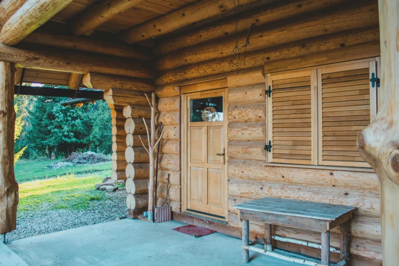 a bench on the porch of a log cabin, a portrait, unsplash, doors to various bedrooms, located in hajibektash complex, profile image, ecovillage