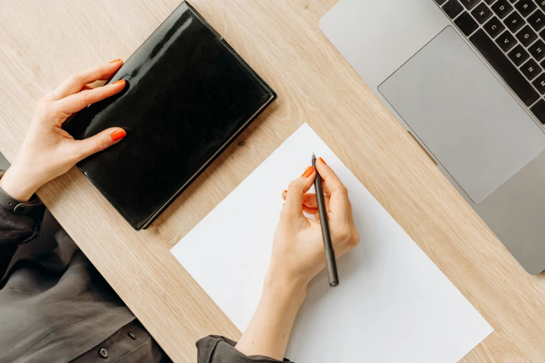 a woman writing on a piece of paper next to a laptop, trending on pexels, plush leather pads, thumbnail, background image, professional vector graphic