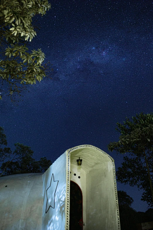 a white toilet sitting under a night sky filled with stars, by Peter Churcher, geodesic building, silo, hut, exterior