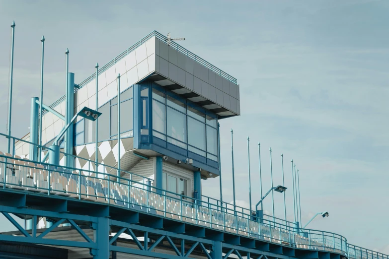 a tall building sitting on top of a bridge, blue and white colour scheme, terminal, seaside, close - up photograph