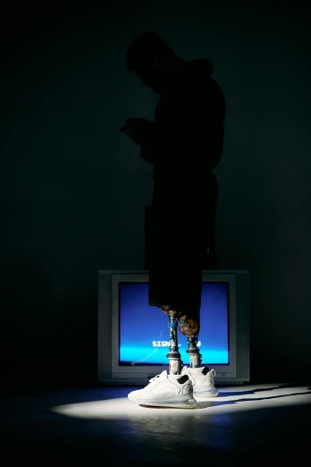 a man standing in front of a tv in the dark, by artist, video art, sneaker made out of lego, shows a leg, late 2000’s, praying