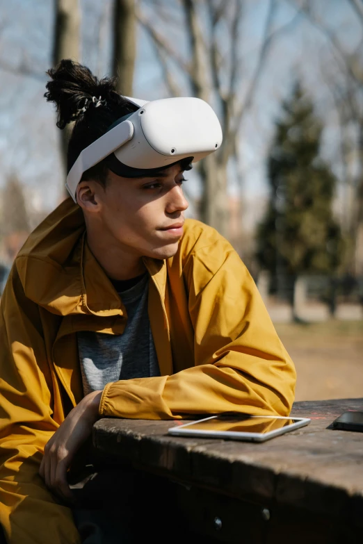 a person sitting at a table with a laptop, oculus quest 2, sitting on a park bench, innocent look, wearing a round helmet