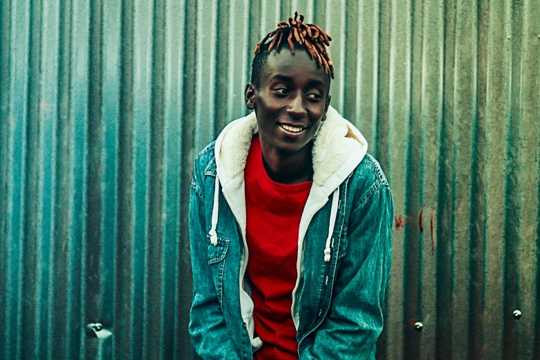 a young man standing in front of a metal wall, pexels contest winner, lil uzi vert, ashteroth, joyful look, adut akech