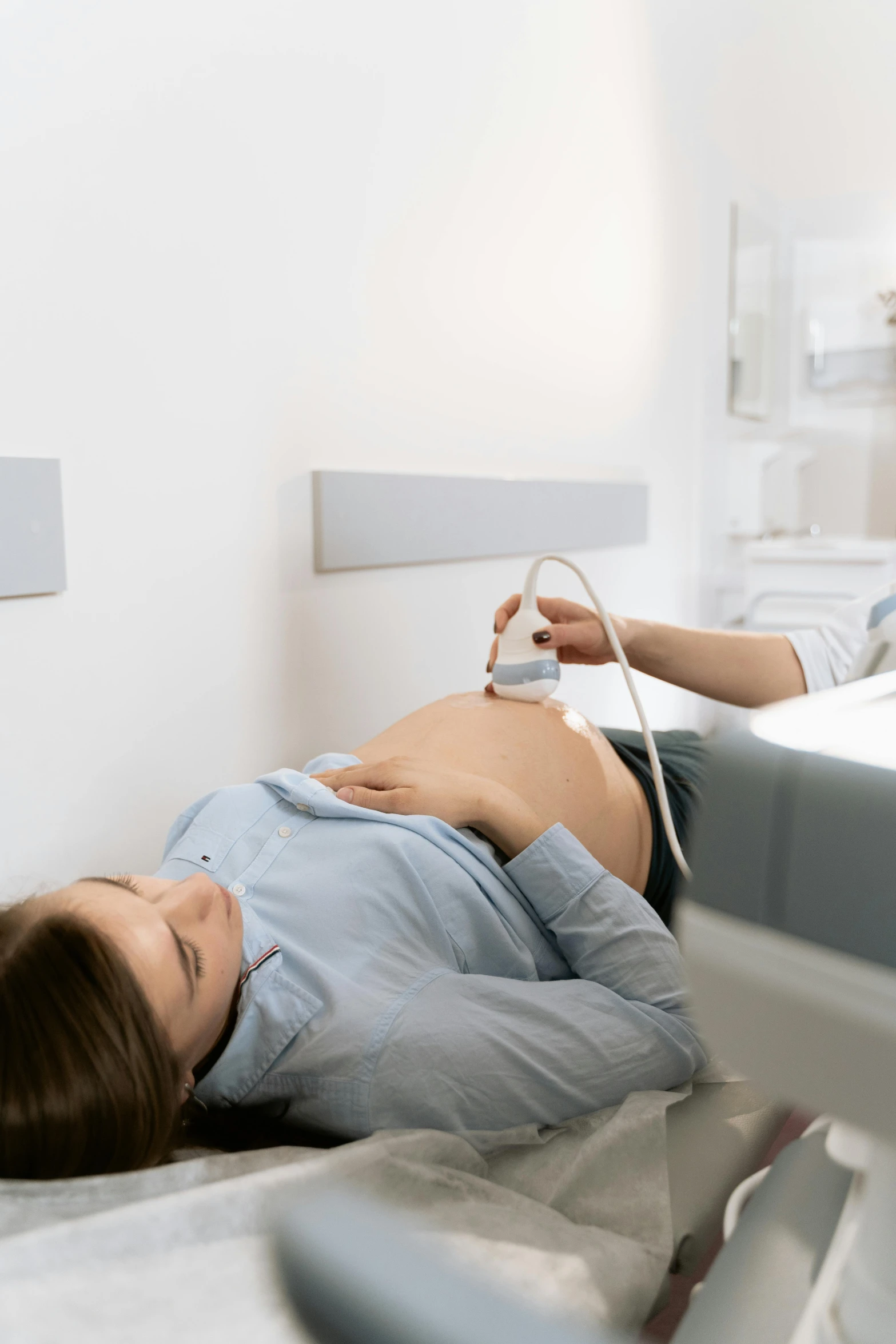 a woman laying on top of a hospital bed, a digital rendering, by Évariste Vital Luminais, shutterstock, pregnant belly, lie detector test, gif, attractive photo