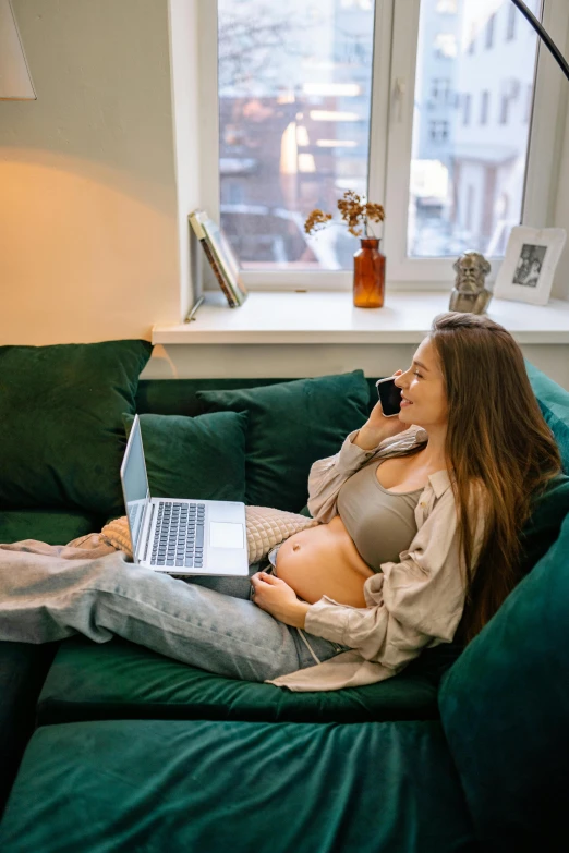 a woman sitting on a couch using a laptop, by Sebastian Vrancx, pexels contest winner, pregnant belly, girl making a phone call, inspect in inventory image, model with attractive body