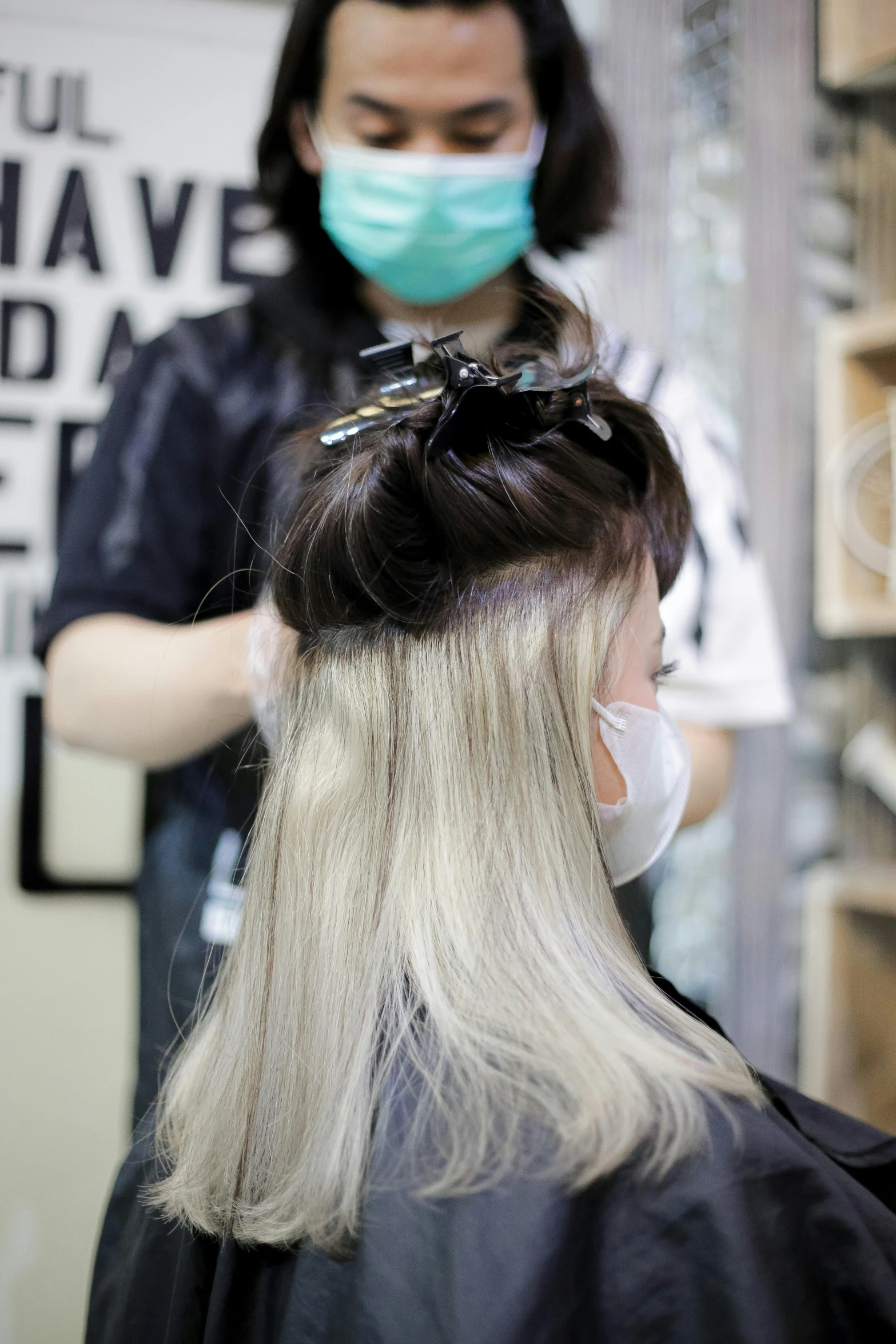 a woman getting her hair cut at a salon, by Aya Goda, trending on pexels, gradient brown to silver, wearing facemask, platinum blonde long hair, hair are wired cables