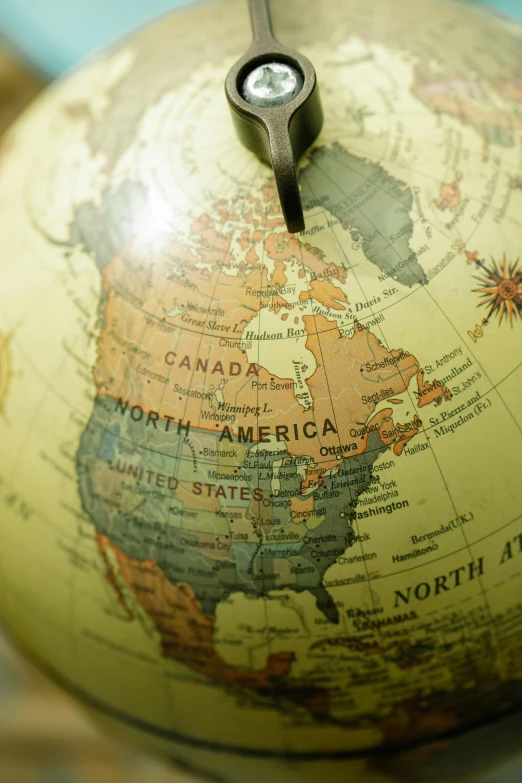 a close up of a clock on top of a globe