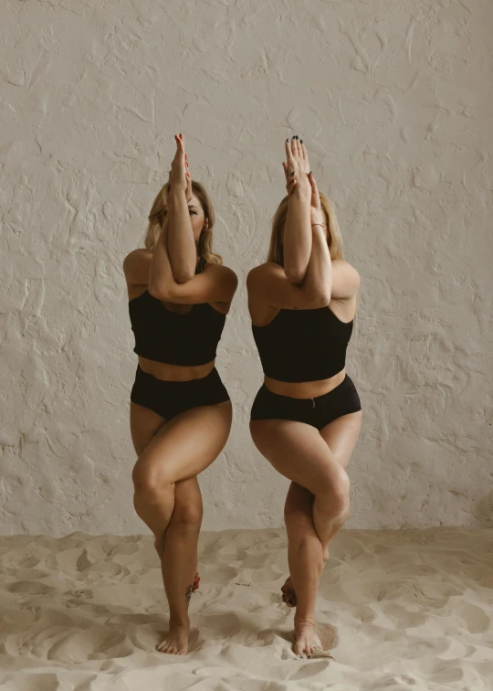 a couple of women that are standing in the sand, trending on unsplash, arabesque, crop yoga short, studio photo, black, sitting on bent knees