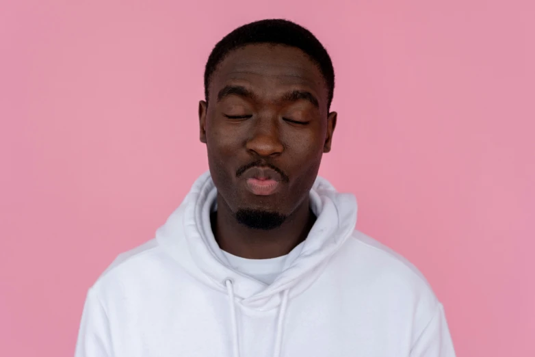 a man in a white hoodie with his eyes closed, inspired by Paul Georges, trending on pexels, smooth pink skin, mkbhd, chocolate, portrait of tall