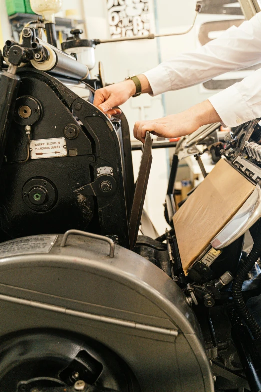 a man working on a machine in a factory, a silk screen, unsplash, private press, rubber stamp, brown, thom browne, thumbnail