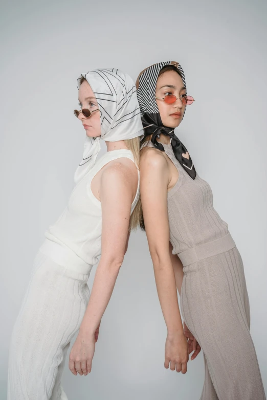 two women standing next to each other wearing scarves, inspired by Gao Cen, trending on pexels, renaissance, wearing a white bathing cap, issey miyake, hair covering eyes, yoko taro