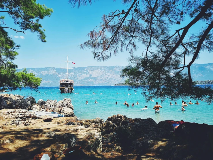 a group of people swimming in a body of water, by Emma Andijewska, pexels contest winner, hurufiyya, croatian coastline, maritime pine, al fresco, christina kritkou