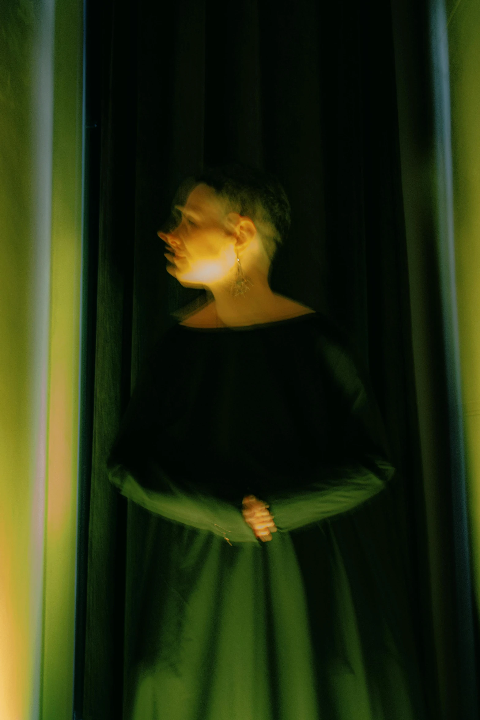 a woman standing in front of a green curtain, an album cover, inspired by Anna Füssli, cold lighting, with short hair, ignant, obscured