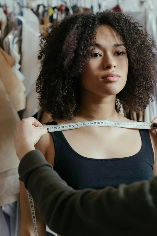 a woman measuring a dress on a mannequin, trending on pexels, renaissance, with afro, big shoulder polster, thumbnail, handsome girl