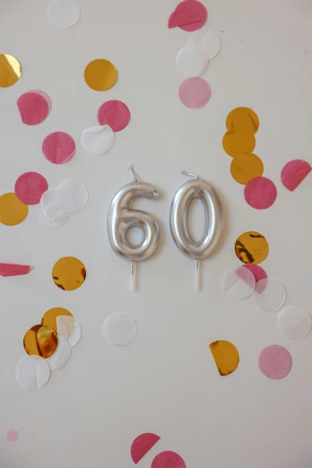 a close up of a cake with a number 60 on it, by Pamela Drew, unsplash, party balloons, silver accessories, candle volumetric, 64x64