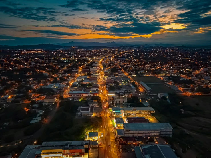 an aerial view of a city at night, by Alejandro Obregón, pexels contest winner, sunset ligthing, city of armenia quindio, tucson arizona, golden hour 8 k
