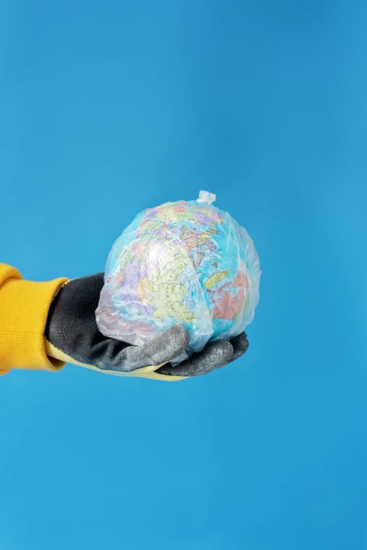 a person in a yellow jacket holding a globe, by Chris Rahn, plasticien, made of cotton candy, planet surface, multi - coloured, detailed product image