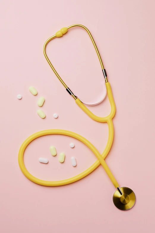 a stethoscope and pills on a pink background, by Winona Nelson, colors: yellow, hero shot, gemma chen, 1 8