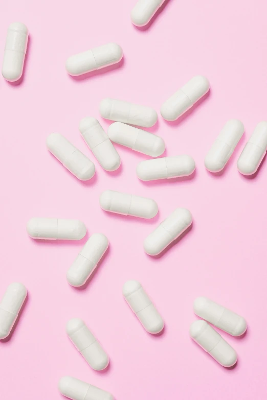 white pills scattered on a pink background, trending on pexels, jen atkin, alien capsules, profile image, made of lab tissue