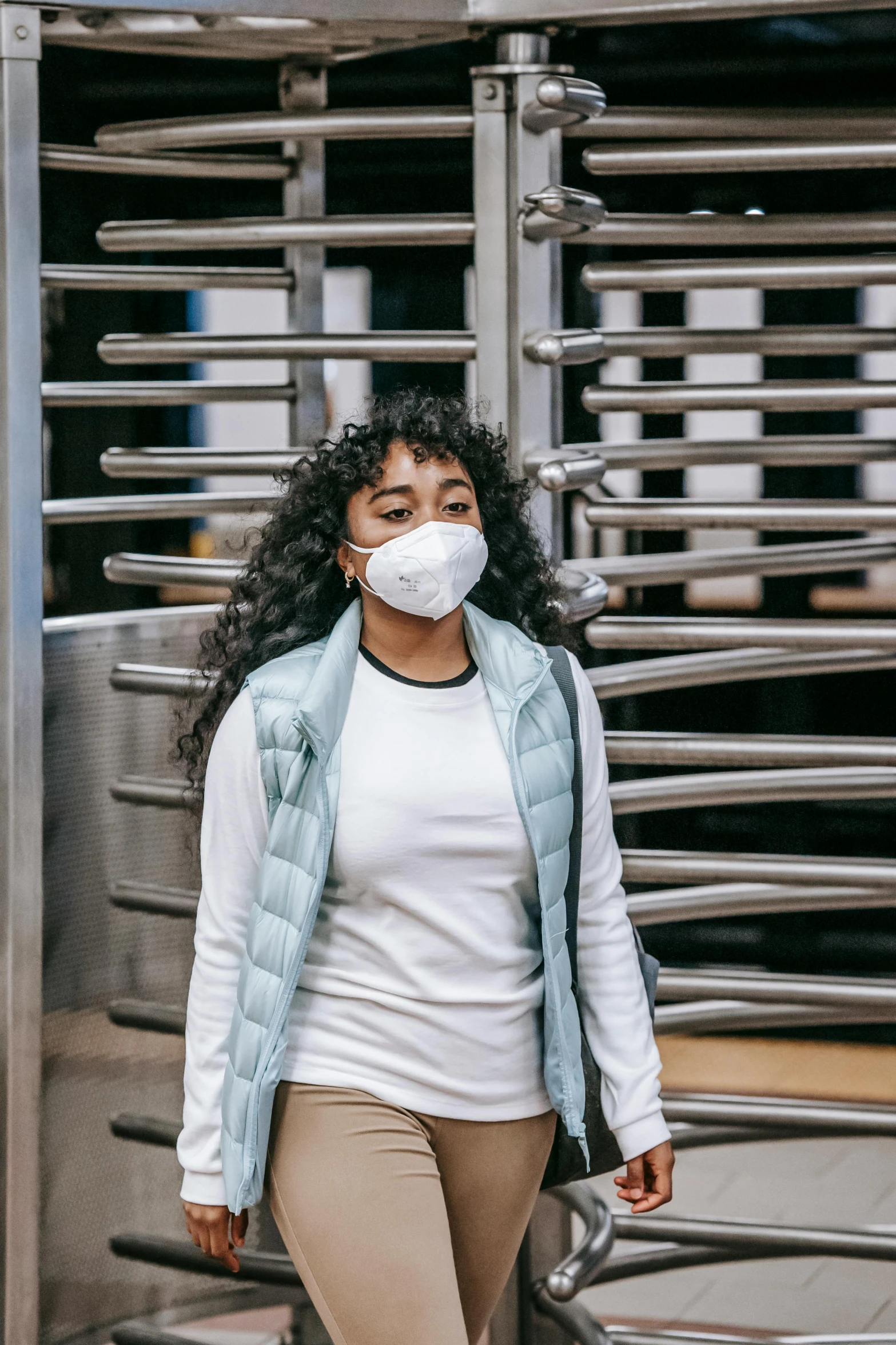 a woman wearing a face mask walking down a street, trending on pexels, renaissance, in an elevator, lungs, curls, stood in a lab