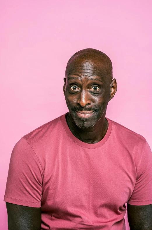 a man in a pink shirt posing for a picture, by Winona Nelson, lance reddick, solid background, heavily upvoted, standup comedian