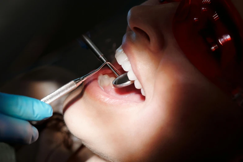 a woman getting her teeth examined by a dentist, by Tom Bonson, pexels contest winner, hurufiyya, micro detail 4k, dingy, thumbnail, discreet lensflare