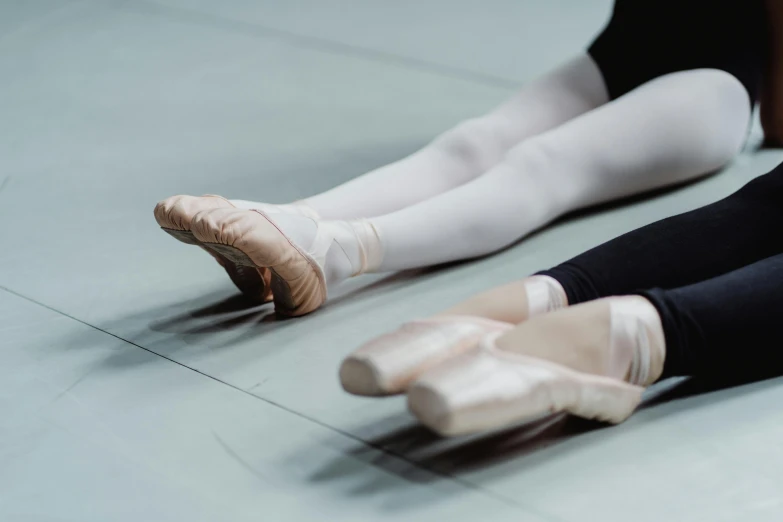 a pair of ballet shoes sitting on the floor, unsplash, arabesque, closeup of arms, panels, silver，ivory, studio floor