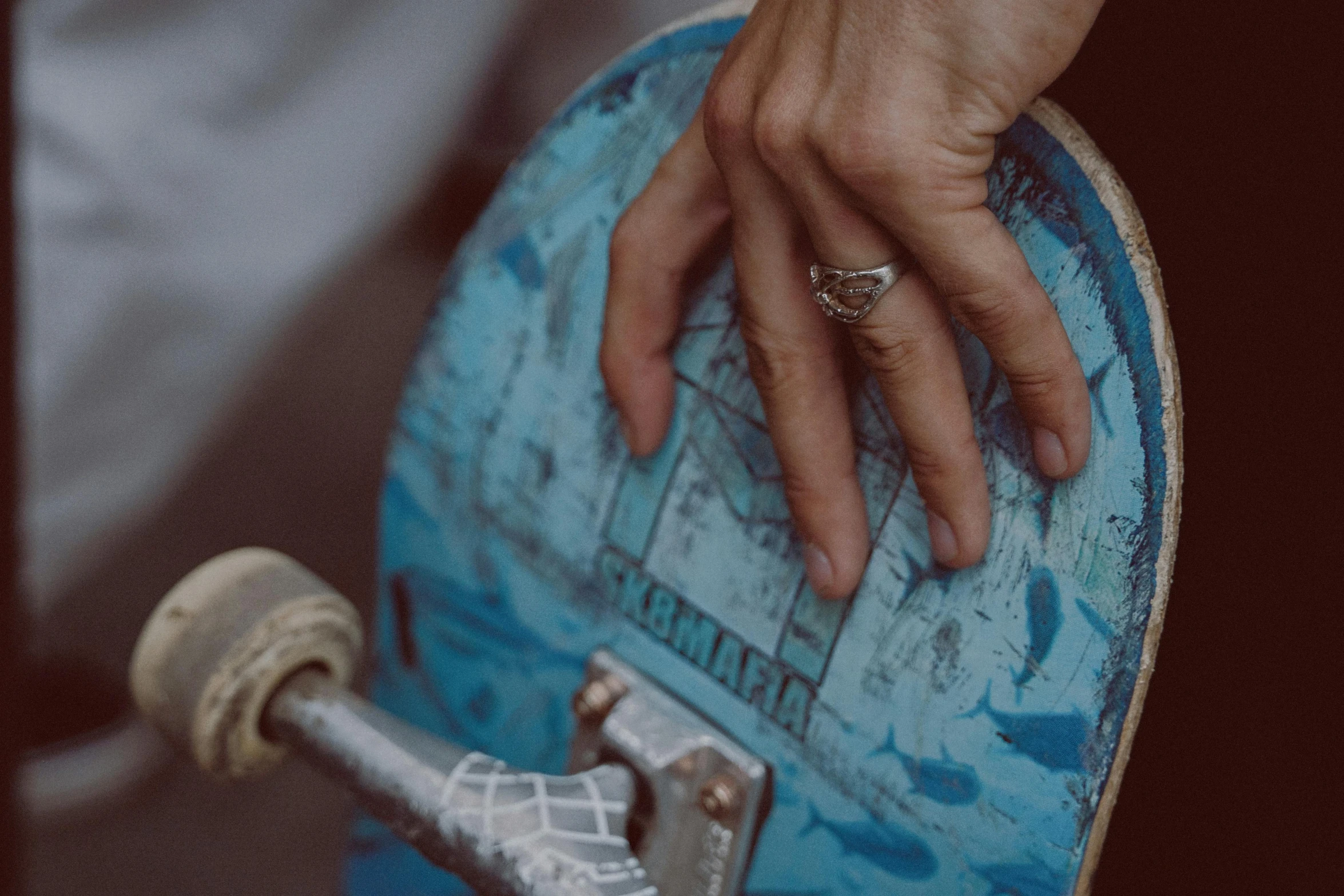 a close up of a person holding a skateboard, by Matija Jama, the ring, blue and grey tones, lots of details, thumbnail